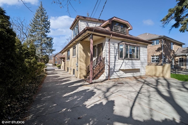 view of home's exterior with brick siding and fence