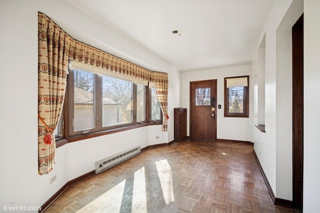 foyer entrance with a baseboard radiator and baseboards