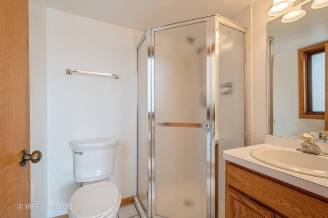 bathroom featuring a stall shower, vanity, and toilet