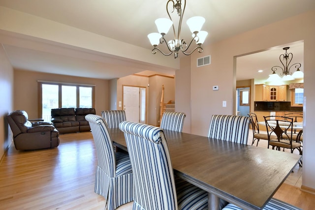 dining space featuring a chandelier, visible vents, and light wood-style floors