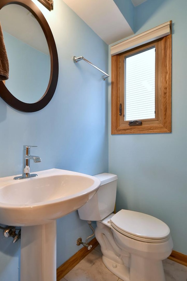 bathroom with toilet and baseboards