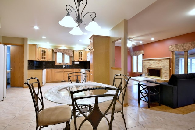 dining room featuring light tile patterned floors, ceiling fan, a brick fireplace, and recessed lighting