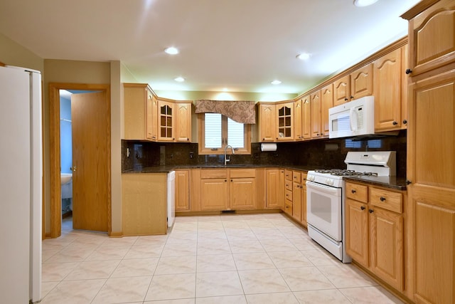 kitchen with white appliances, tasteful backsplash, glass insert cabinets, and a sink