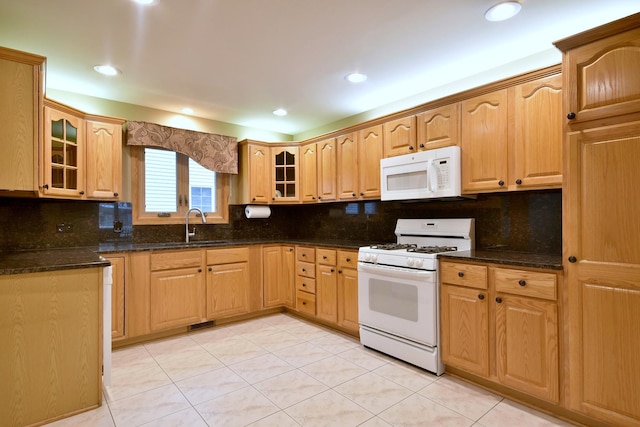 kitchen featuring glass insert cabinets, white appliances, a sink, and backsplash