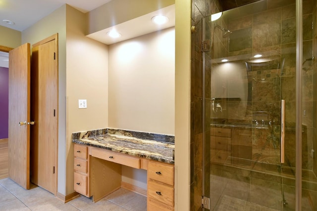 bathroom with a stall shower, tile patterned flooring, and vanity