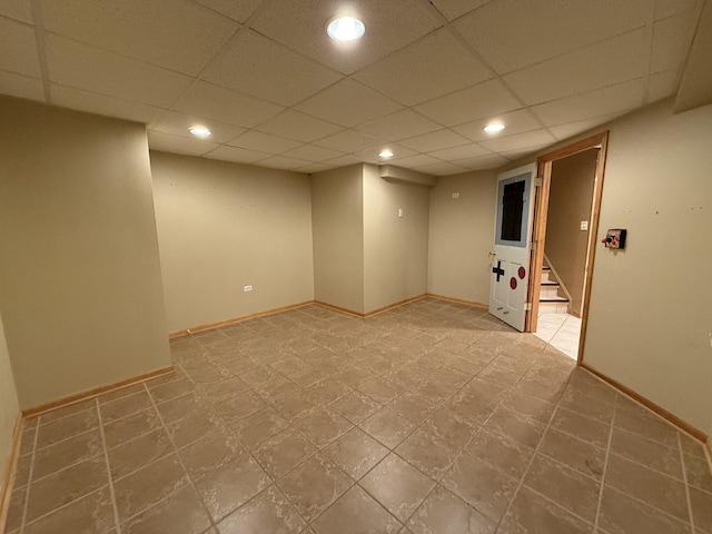 finished basement with stairway, recessed lighting, a paneled ceiling, and baseboards