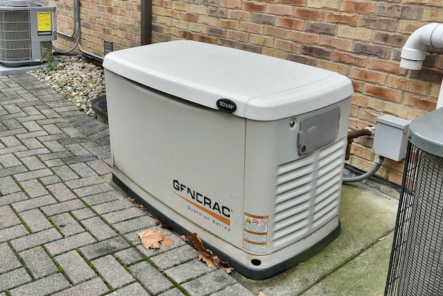 exterior details featuring cooling unit, brick siding, and a power unit