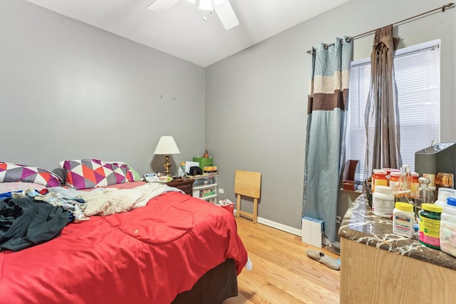 bedroom featuring lofted ceiling, light wood-type flooring, a ceiling fan, and baseboards