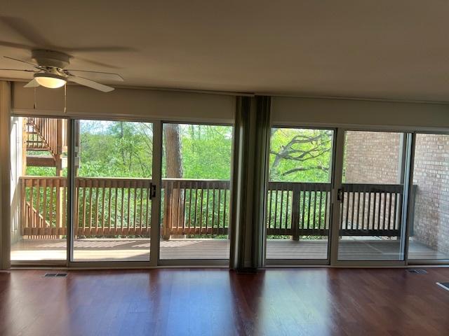 unfurnished sunroom with visible vents and ceiling fan