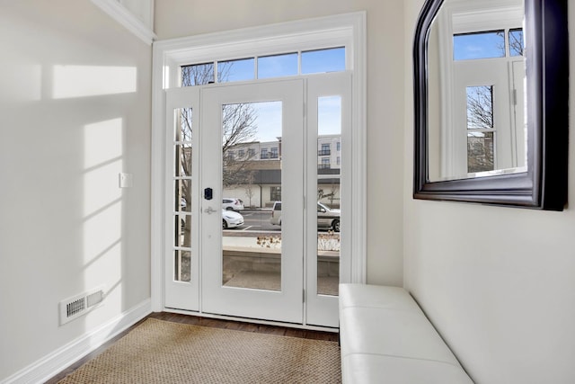 doorway with visible vents, baseboards, and wood finished floors