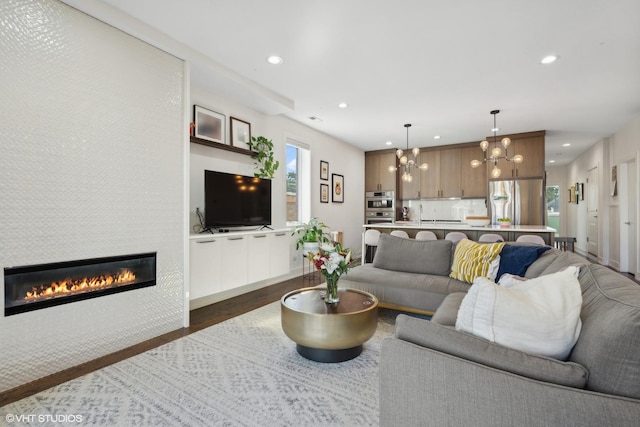 living area featuring a tile fireplace, an inviting chandelier, dark wood finished floors, and recessed lighting