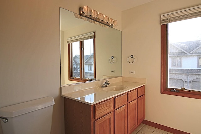 half bathroom featuring toilet, vanity, and tile patterned floors