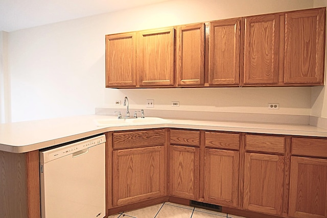 kitchen featuring light tile patterned floors, white dishwasher, a peninsula, a sink, and light countertops