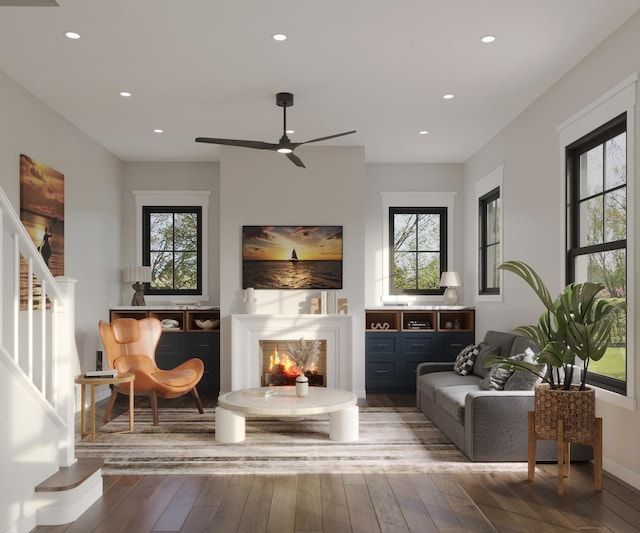 sitting room featuring a warm lit fireplace, a healthy amount of sunlight, and hardwood / wood-style flooring