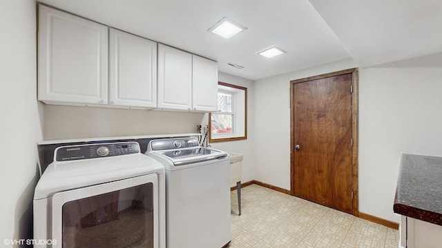 laundry room with light floors, washing machine and dryer, cabinet space, and baseboards