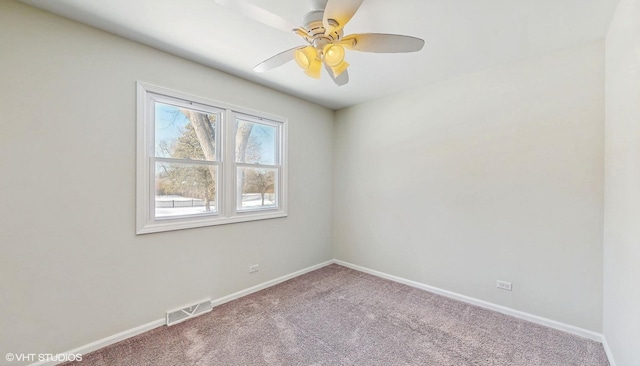 empty room with carpet floors, baseboards, visible vents, and a ceiling fan