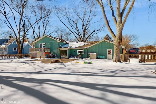 view of front of house with fence, a fire pit, and a wooden deck