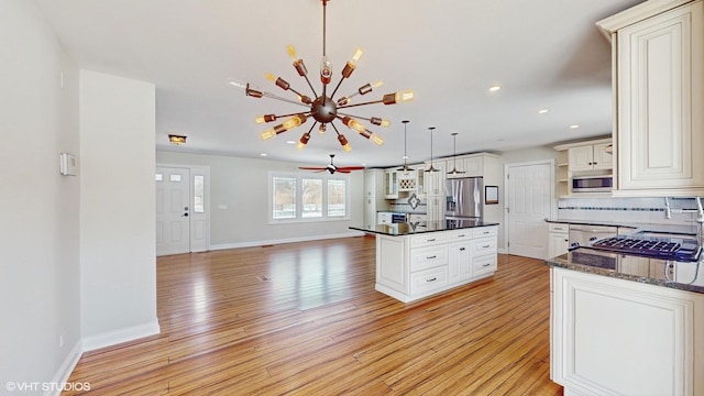 kitchen with stainless steel appliances, baseboards, light wood-style flooring, and decorative backsplash