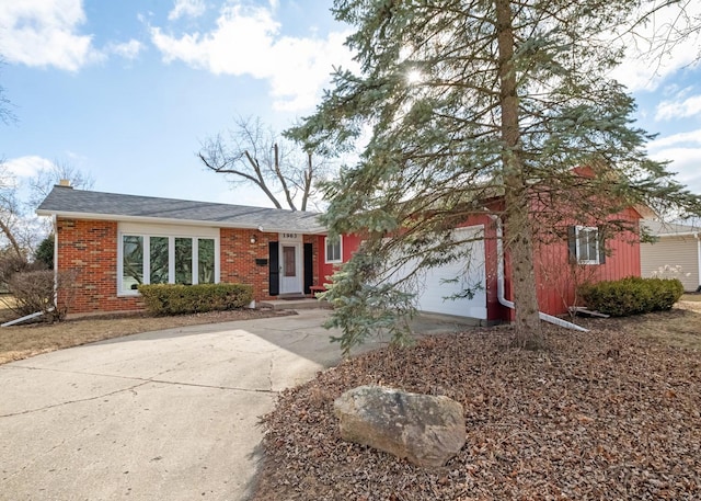 ranch-style home featuring an attached garage, concrete driveway, and brick siding