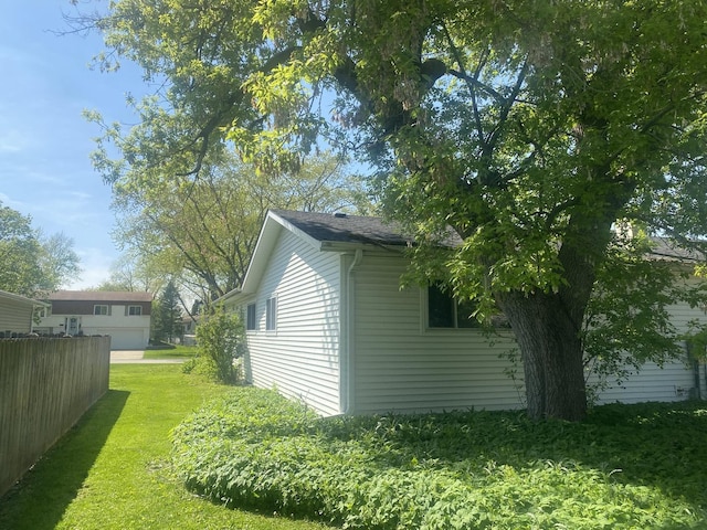 view of home's exterior with a yard and fence