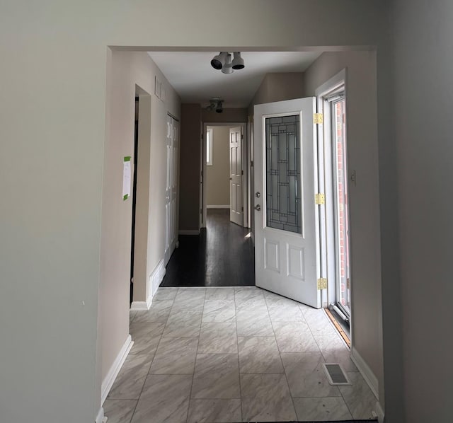 foyer entrance with baseboards, visible vents, and a wealth of natural light