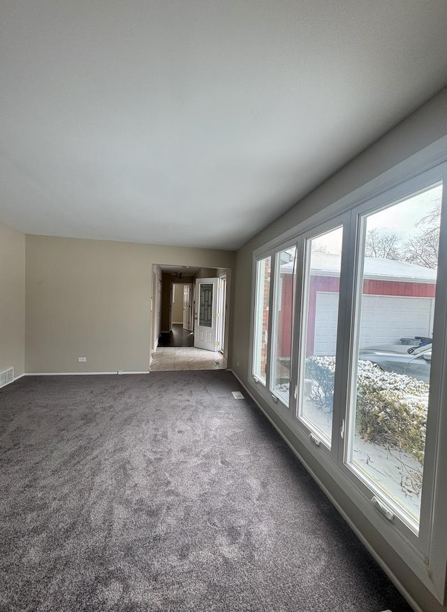 carpeted empty room with visible vents and baseboards