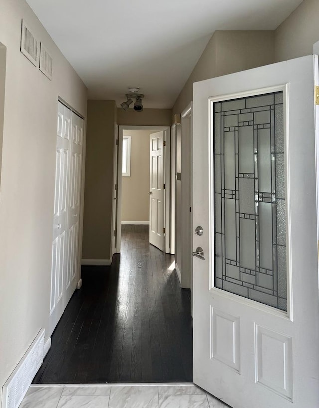 entryway with wood finished floors, visible vents, and baseboards