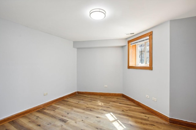 spare room with visible vents, baseboards, and wood finished floors