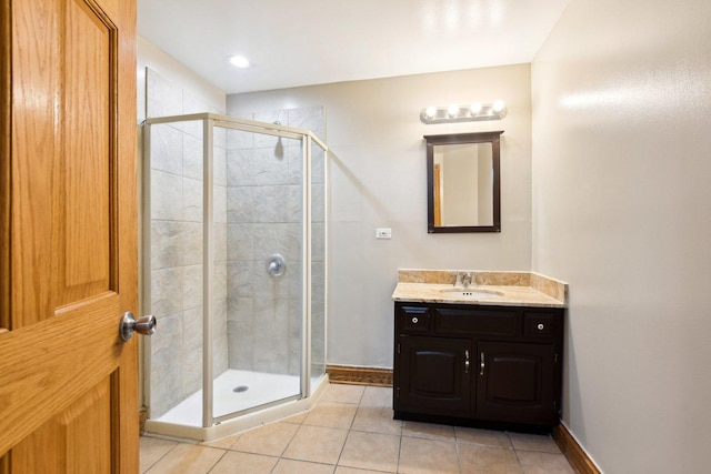 full bathroom with baseboards, a shower stall, vanity, and tile patterned floors