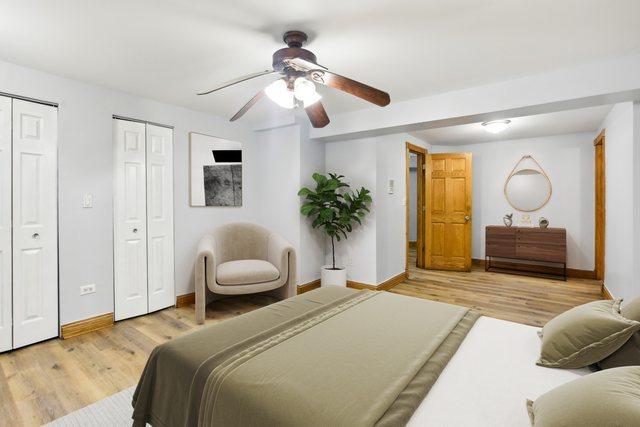 bedroom with multiple closets, ceiling fan, baseboards, and wood finished floors