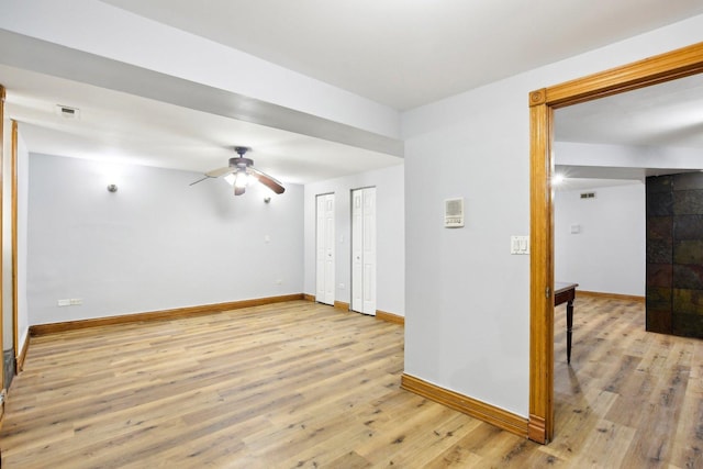 unfurnished room with a ceiling fan, light wood-style flooring, and baseboards