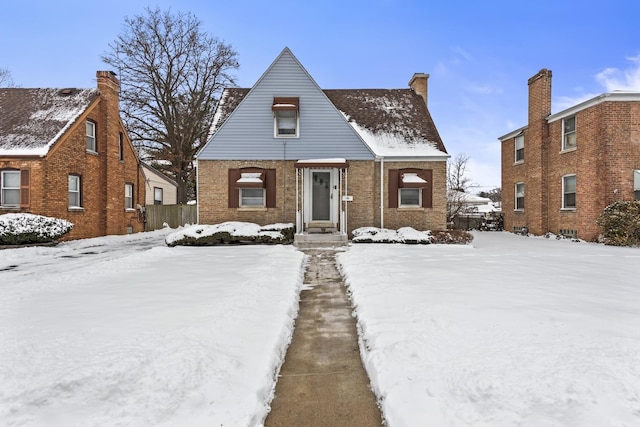 view of front of house featuring brick siding and a chimney