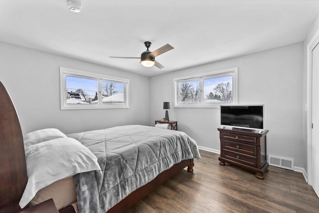 bedroom with ceiling fan, dark wood finished floors, visible vents, and baseboards