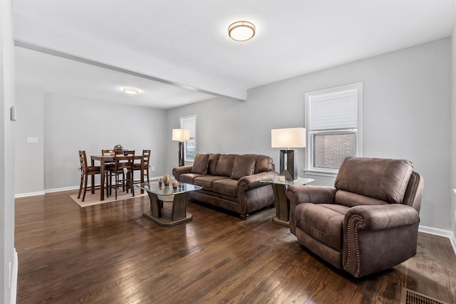 living room with beamed ceiling, dark wood finished floors, visible vents, and baseboards