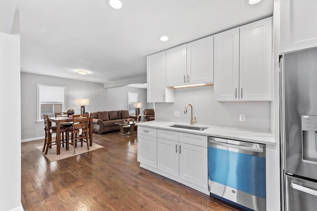 kitchen with white cabinets, stainless steel fridge, dishwasher, and a sink