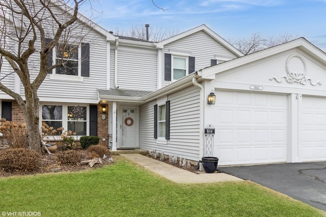 view of front of home with an attached garage, driveway, and brick siding