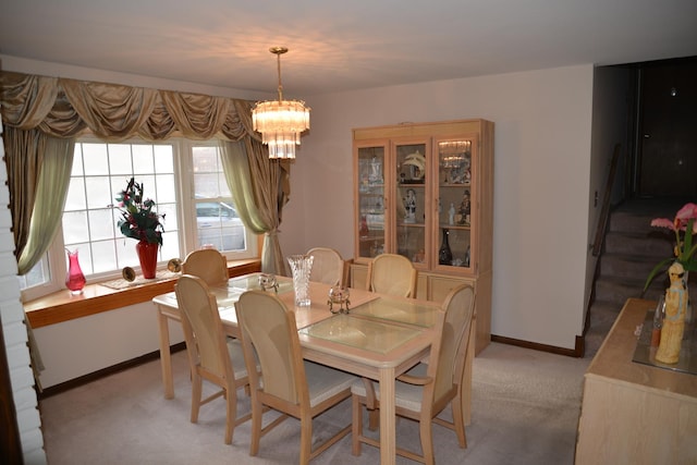 dining room featuring light carpet, baseboards, and an inviting chandelier