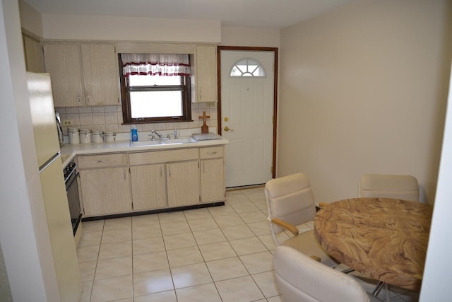 kitchen featuring range, light countertops, a sink, and decorative backsplash