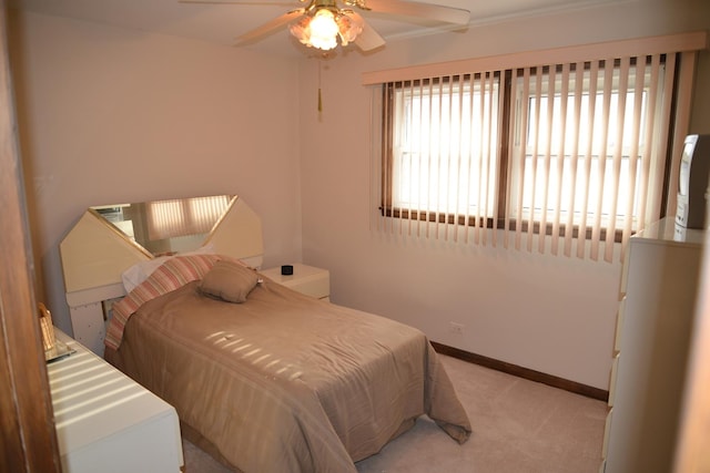 bedroom featuring ceiling fan, baseboards, and light colored carpet