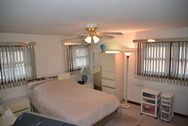 carpeted bedroom featuring a ceiling fan and baseboards