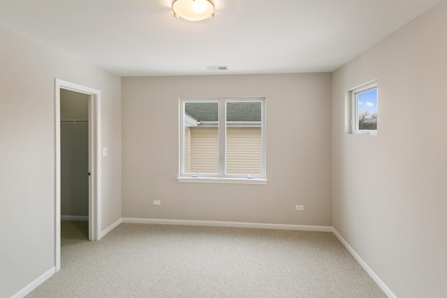 spare room featuring light carpet, baseboards, and visible vents