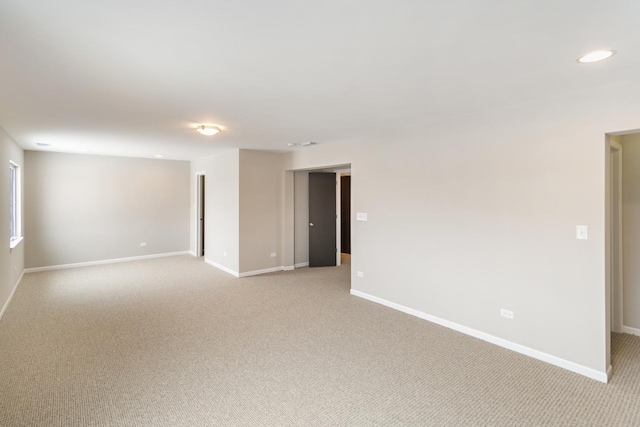 empty room with recessed lighting, light colored carpet, and baseboards