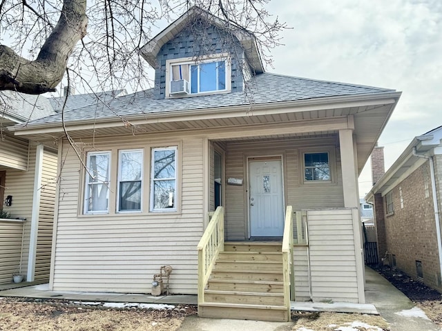 bungalow featuring a shingled roof, cooling unit, and a porch