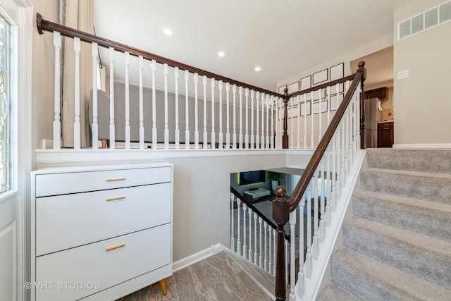 staircase with recessed lighting, visible vents, and baseboards