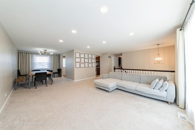 living room with a notable chandelier, recessed lighting, baseboards, and light carpet