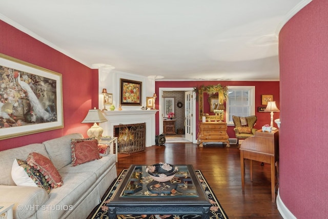 living room with ornamental molding, a lit fireplace, and wood finished floors