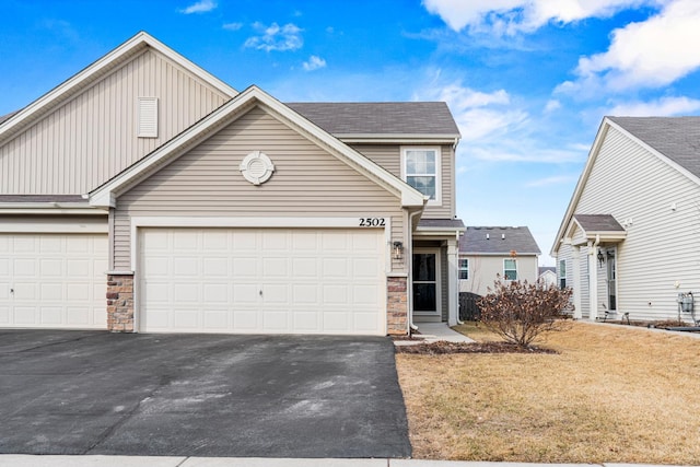 view of front of home featuring driveway, a garage, and a front yard