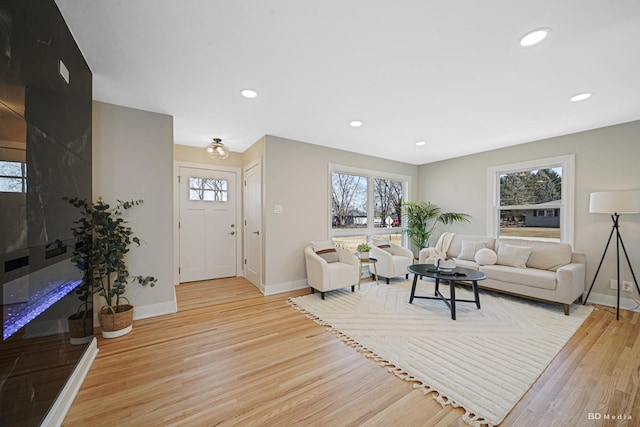 living room with recessed lighting, light wood-type flooring, and baseboards