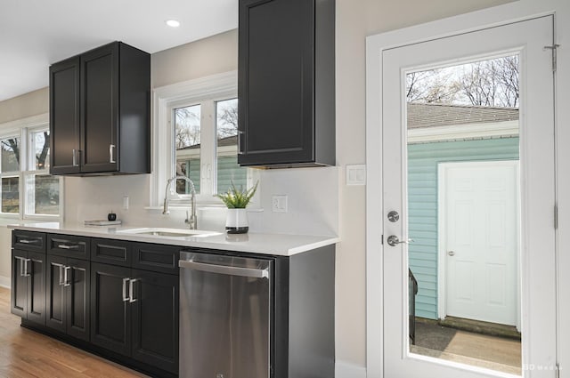 kitchen featuring a sink, plenty of natural light, stainless steel dishwasher, and light countertops