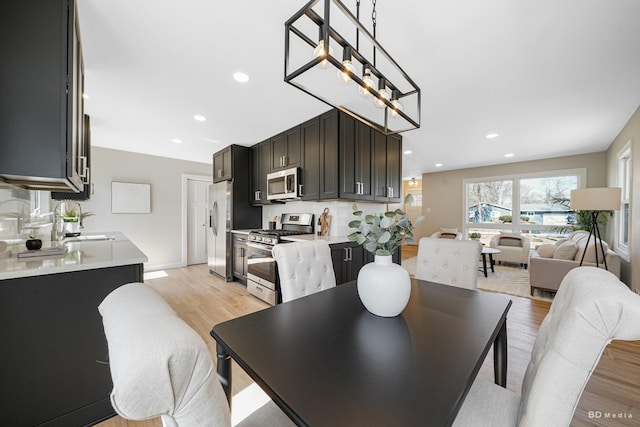 dining area with recessed lighting and light wood-style floors